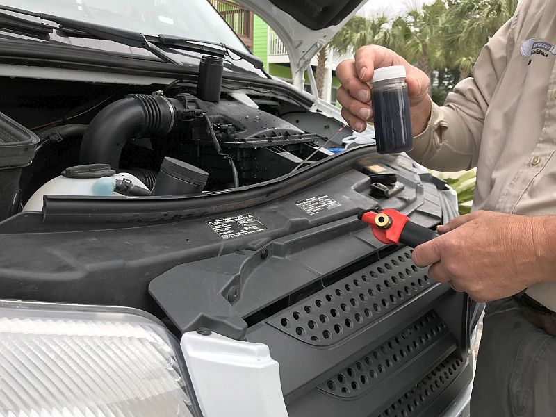 The RV Inspector is pulling fluid from an engine to send to a lab.